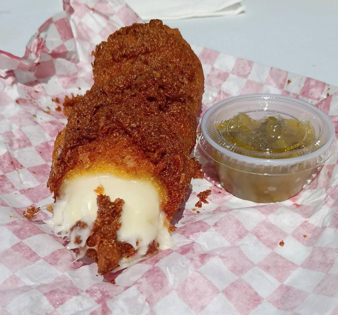 Fried mozzarella dog from Donny's Dogs with melted cheese inside and a side of relish