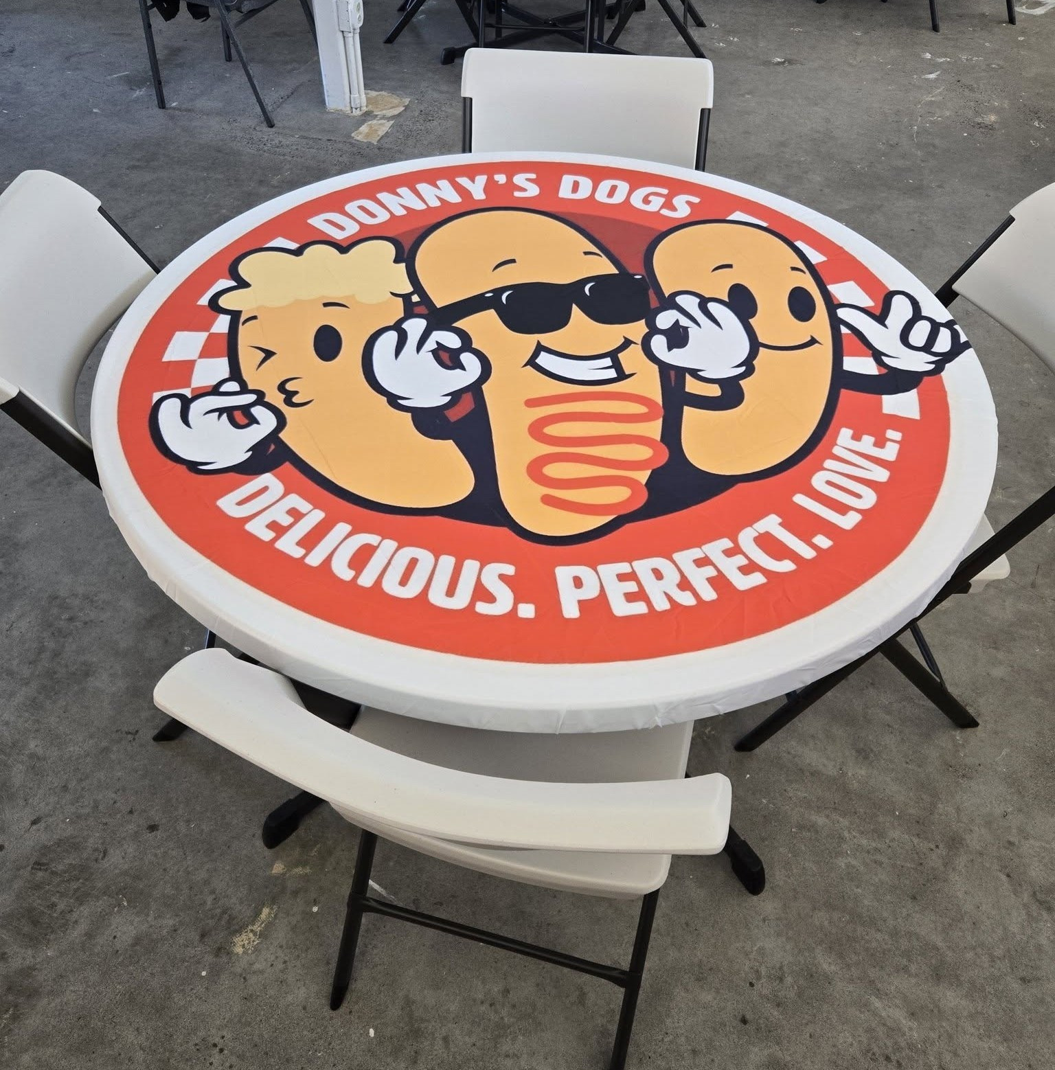 Donny's Dogs table with the Delicious. Perfect. Love. logo